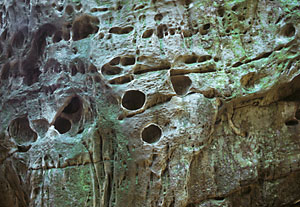 A boulder with round holes in the sides.